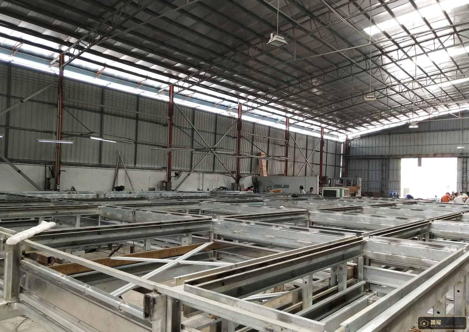 Long metal sub-frames laid out in parallel rows across a workshop floor