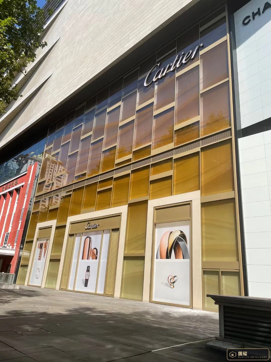 Cartier facade in daylight, brushed gold metal screen with the display windows below